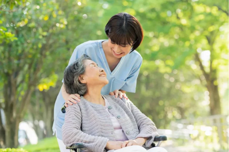 車椅子に乗っている女性に優しく話しかける女性