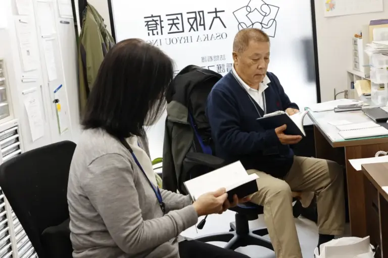 大阪医療のオフィスで資料をみる女性と男性